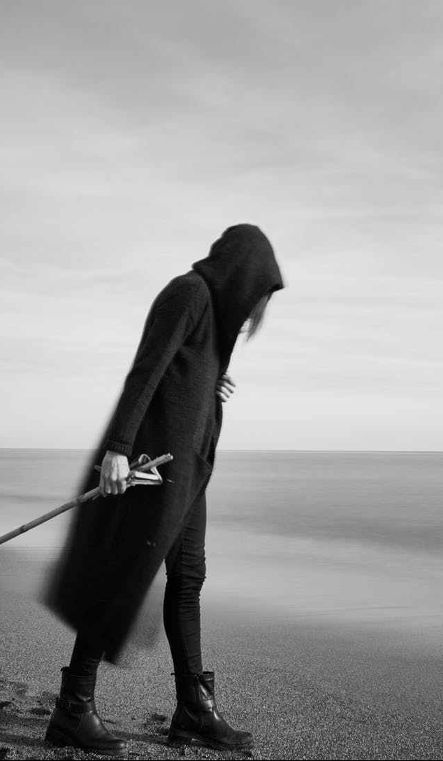 man in cloak on beach